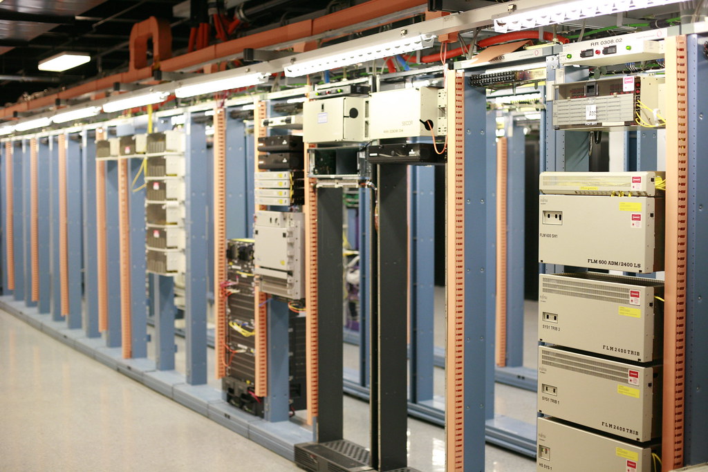 An aisle of telecom equipment racks in a network operating centre. Photograph by Robert Scoble.